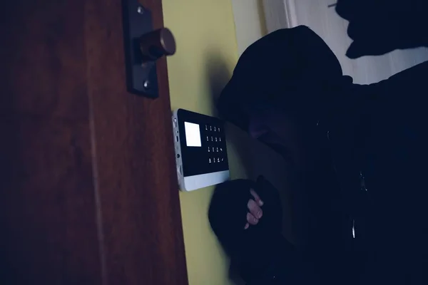 Robo en un apartamento por la noche. El ladrón desarma la alarma.. — Foto de Stock
