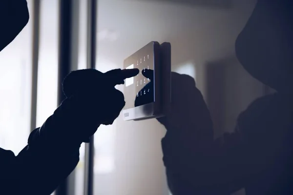 La mano masculina de un ladrón presionando el código para una alarma doméstica. —  Fotos de Stock