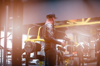 Vücut geliştirici spor salonunda aynanın önünde egzersiz yapıyor..