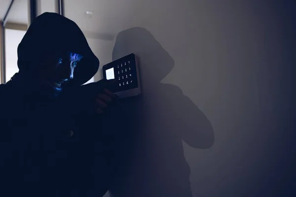 Robo en el apartamento por la noche. Un intento de desarmar la alarma por un ladrón. —  Fotos de Stock