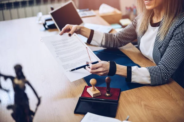 Woman notary public holding pen and pointing at signature place. — Stock Photo, Image