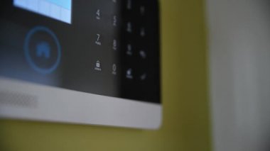 Mans El ve parmak alarm kodunu itiyor ya da basıyor.