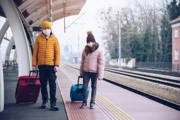 Kinder mit Schutzmasken auf einem Bahnhof während einer Pandemie. — Stockfoto