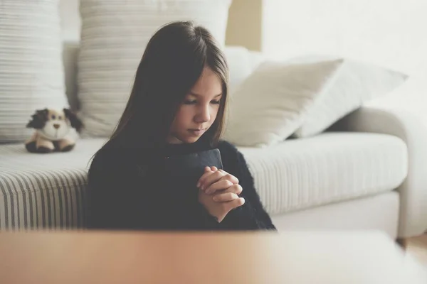 Hübsches kleines Mädchen betet in ihrem Haus. — Stockfoto