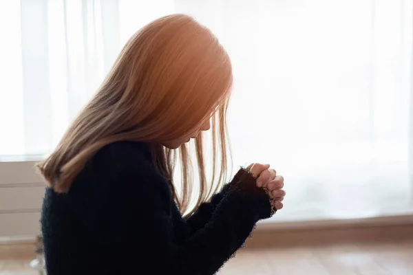 Chica joven con el pelo largo centrado en la oración en casa. — Foto de Stock