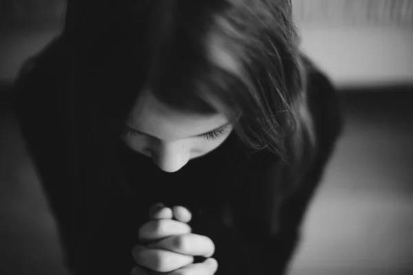 Uma menina orando com as mãos unidas em oração. — Fotografia de Stock