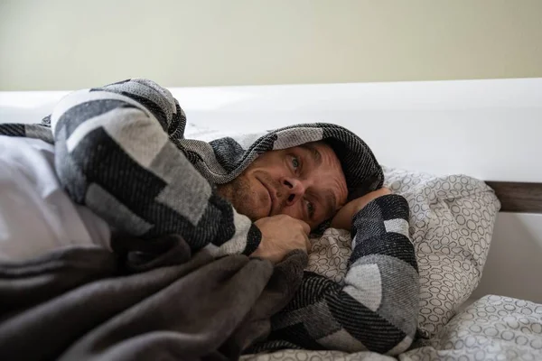 Depressed man lying in his bed and feeling bad. — Stock Photo, Image