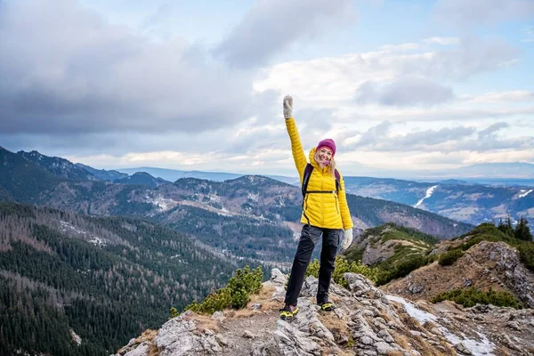 Hiker woman standing with hands up achieving the top. — Stock Photo, Image