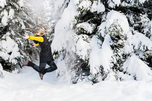 Прекрасні зимові пейзажі. Жінка стрибає на снігу . — стокове фото