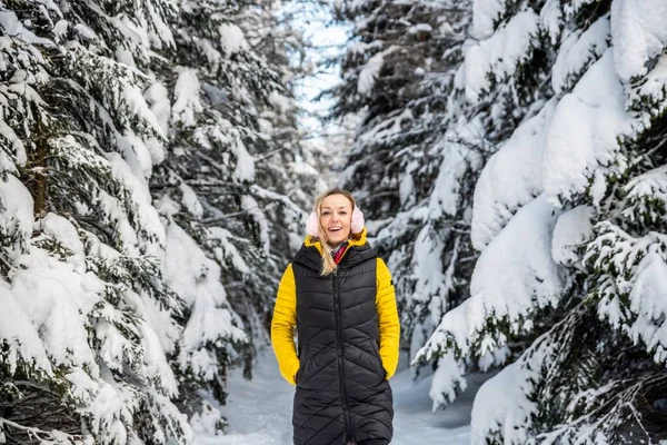 Leende blond turist går längs en bergsstig på en vacker vinterdag. — Stockfoto