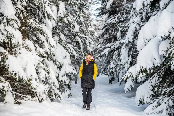 En blond turist går längs en bergsstig en vacker vinterdag. — Stockfoto