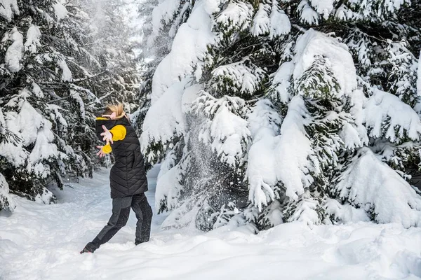 Una donna sta saltando nella neve in una bella giornata invernale. — Foto Stock