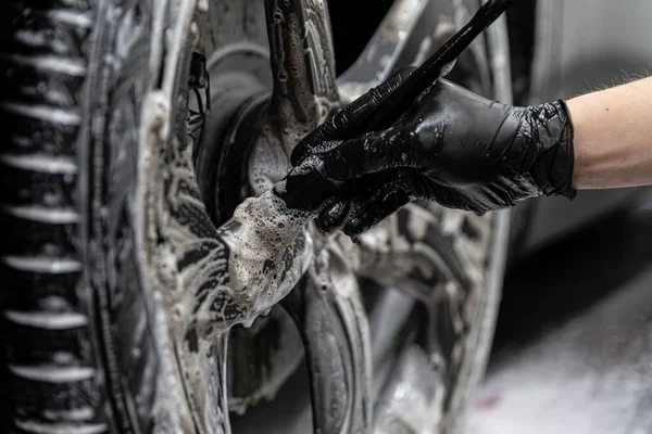 男の車の洗浄やスタジオ作業員の清掃車やタイヤの詳細 — ストック写真