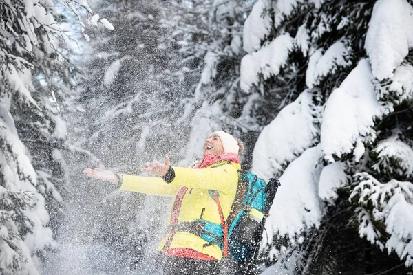 一个美丽的微笑的游客在下着雪。美丽的冬季风景. — 图库照片