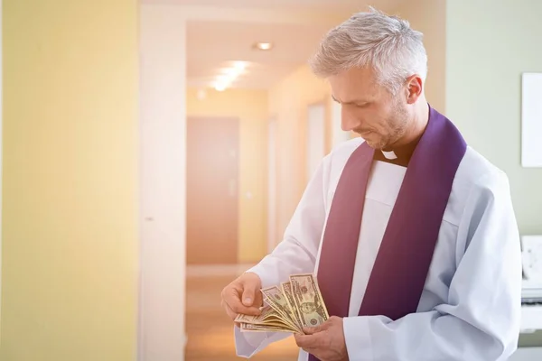 Catholic cleric priest counting american money dollar.