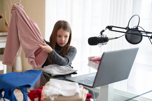 Una giovane bella vlogger mostra i suoi vestiti online mentre è seduta a casa. — Foto Stock