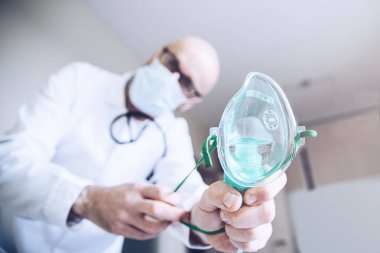 Hastanedeki doktor oksijen maskesi takıyor. Solunum problemleri