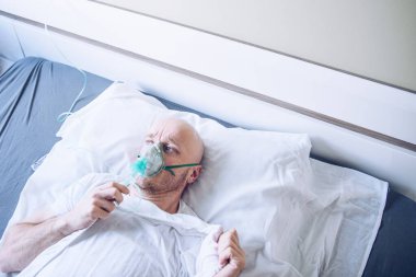 Coronavirus hasta adam oksijen maskesi ile nefes alıyor. Hastanedeki hasta..