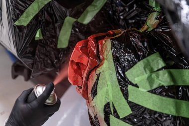 Tamirci fren kalibrelerini kırmızı boyayla boyuyor.