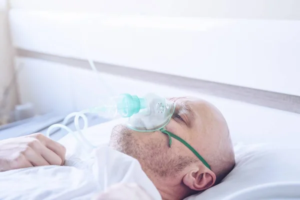 Hombre enfermo con problemas respiratorios con máscara de oxígeno o ventilato — Foto de Stock