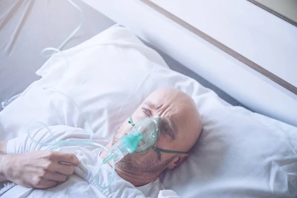 Hombre enfermo con problemas respiratorios con máscara de oxígeno o ventilato — Foto de Stock