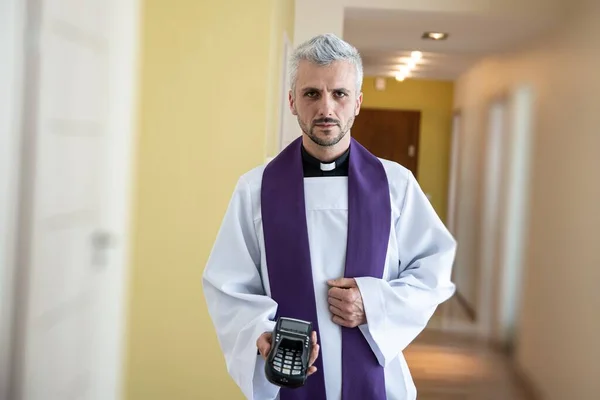 Sacerdote com leitor de cartões visita os fiéis. — Fotografia de Stock