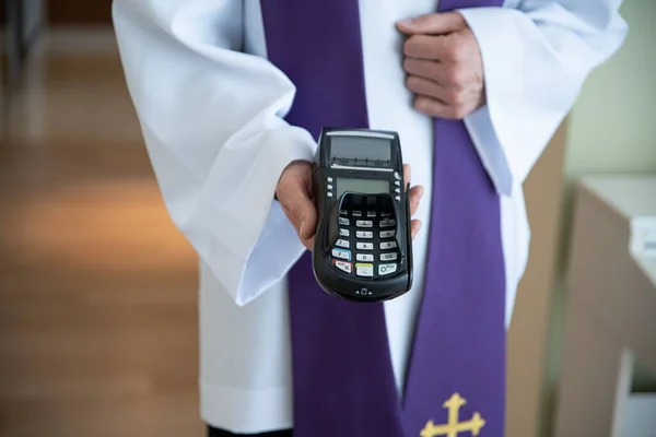 Lecteur de carte dans la main d'un prêtre lors d'une visite pastorale. — Photo