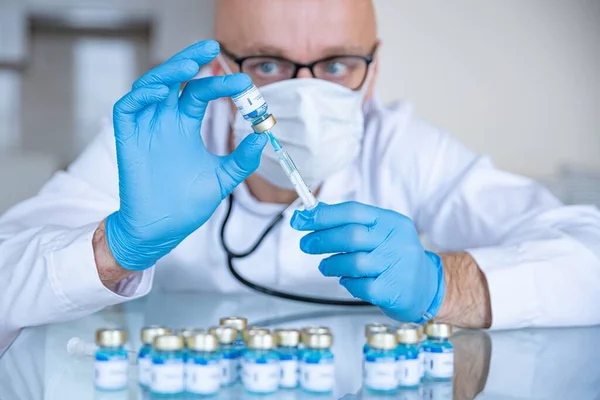 Vacunación contra el Coronavirus. Médico en máscara médica y guantes prepara vacunas. — Foto de Stock