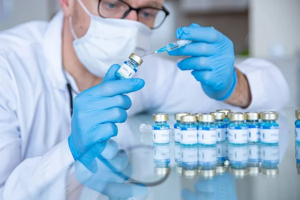 El médico está preparando vacunas para los pacientes. Tiempo de la pandemia. — Foto de Stock