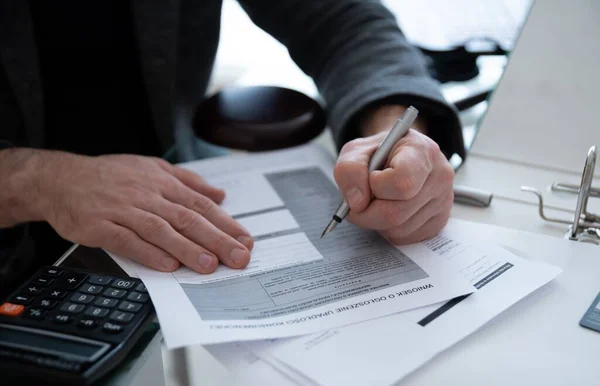 Um homem assina um documento com cartas de falência. Notificação de falência. — Fotografia de Stock