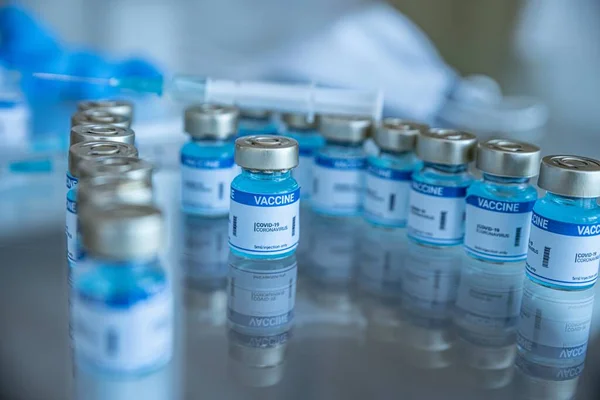 Ampollas con vacuna Covid-19 en un banco de laboratorio. Para luchar contra el coronavirus. — Foto de Stock