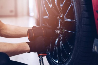 Araç lastiği ve tekerleği mekanik serviste değiştiriliyor.