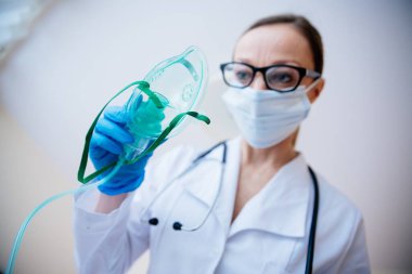 Oksijen maskesi tutan bir doktorun yakın çekimi..