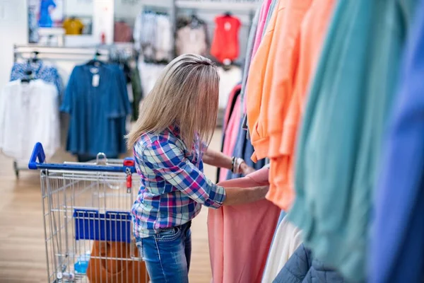 Nő vásárlás közben egy ruhaboltban vagy szupermarketben. — Stock Fotó
