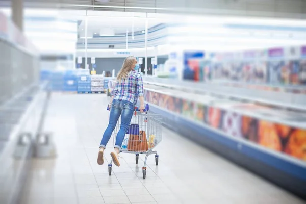 Kobieta dobrze się bawi z wózkiem z supermarketem. Robi zakupy.. — Zdjęcie stockowe