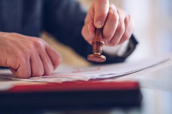 Close-up of the hand of a notary who manually stamps the document. — Stock Photo, Image