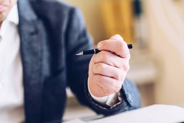 Een advocaat, notaris, tekent een belangrijk document. Pen in zijn hand. — Stockfoto