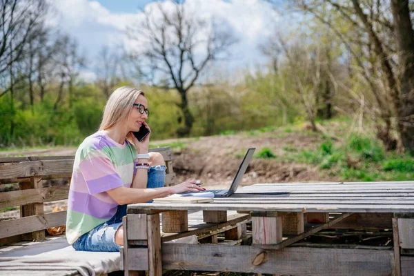 Frau mit Brille arbeitet an einem schönen sonnigen Tag im Freien. — Stockfoto
