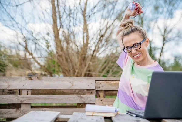 Pissed off blonde with glasses destroys her notes and throws them in front of her. Office outside. — Stockfoto