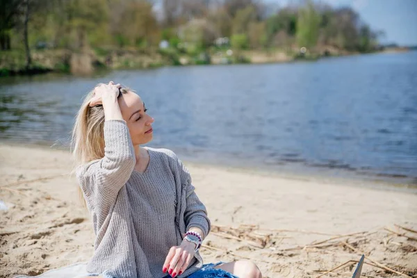 Happy blonde woman works remotely in beautiful sunny weather.