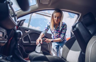 Arabanın içini temizleyen kadın. Temizlik kavramı.