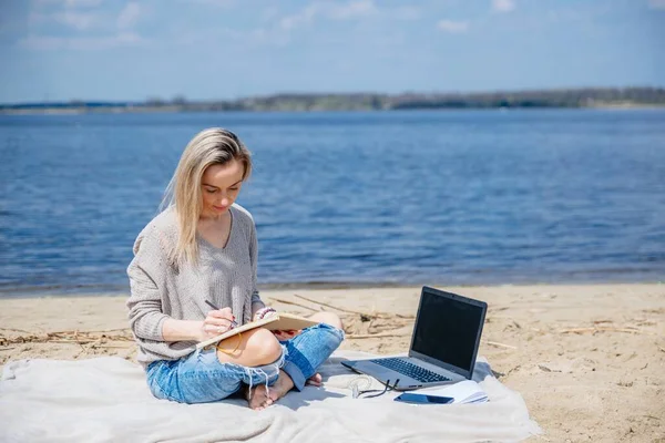 Glückliche Hipsterfrau, die mit ihrem Laptop auf der Decke sitzt. — Stockfoto