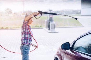 Otomobil yıkamada ekose gömlekli bir kadın.