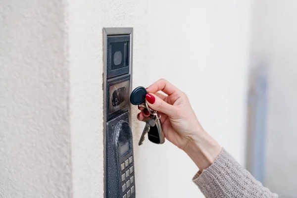 Una mano femenina utiliza un mando a distancia para una alarma doméstica. —  Fotos de Stock