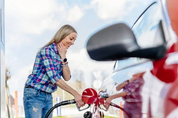 Mulher bonita enchendo seu carro com gasolina no posto de gasolina. — Fotografia de Stock