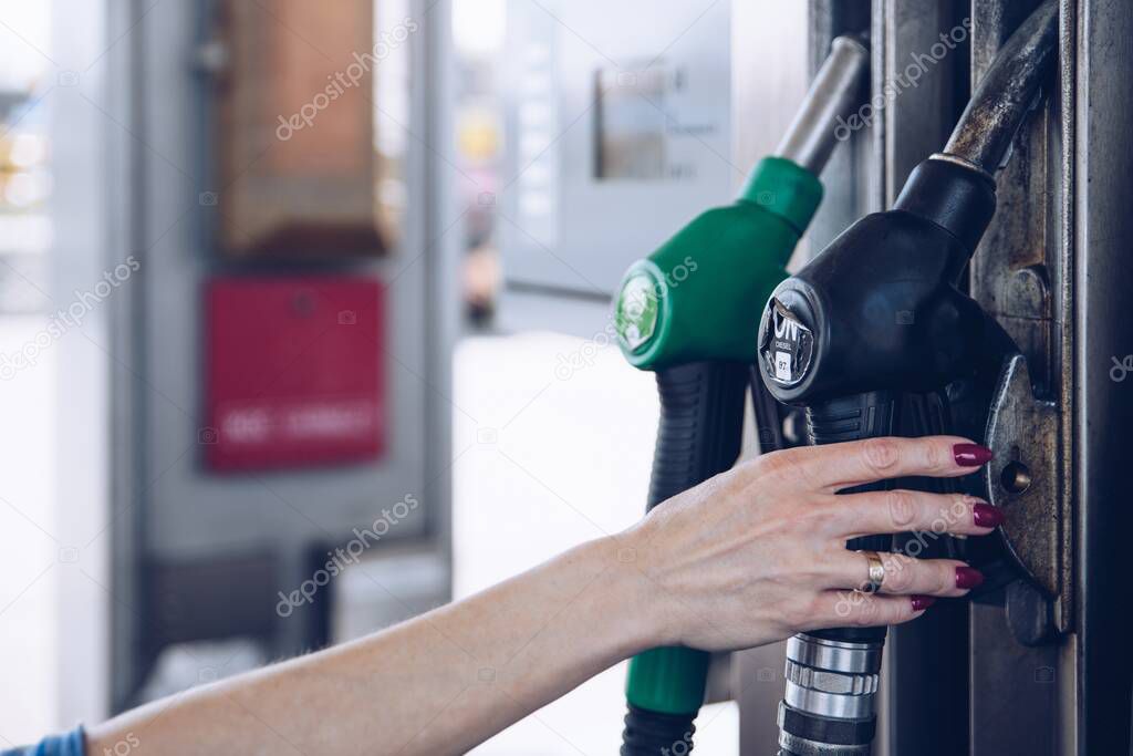 Gasoline and diesel distributor at the gas station. The woman is going to refuel the car.