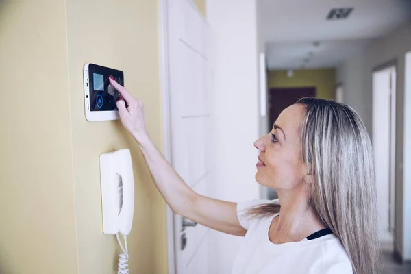 Bir kadın alarm sistemini etkisiz hale getirmek için kontrol panelindeki düğmelere basıyor. — Stok fotoğraf