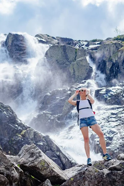 Femme debout sur le rocher et profitant de la vue sur la cascade de Siklawa. — Photo