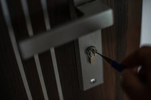 Close-up of a persons hand opening door with lockpicke — Stock Photo, Image