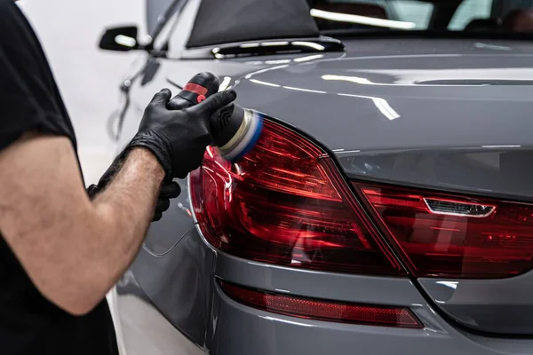 Detallando trabajador del estudio renovando la lámpara del coche Imágenes De Stock Sin Royalties Gratis